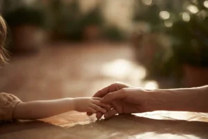 A_childs_small_hand_resting_in_an_adults_hand